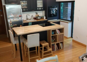 Plans de travail de cuisine et petite bibliothèque intégrée en frêne et noyer.